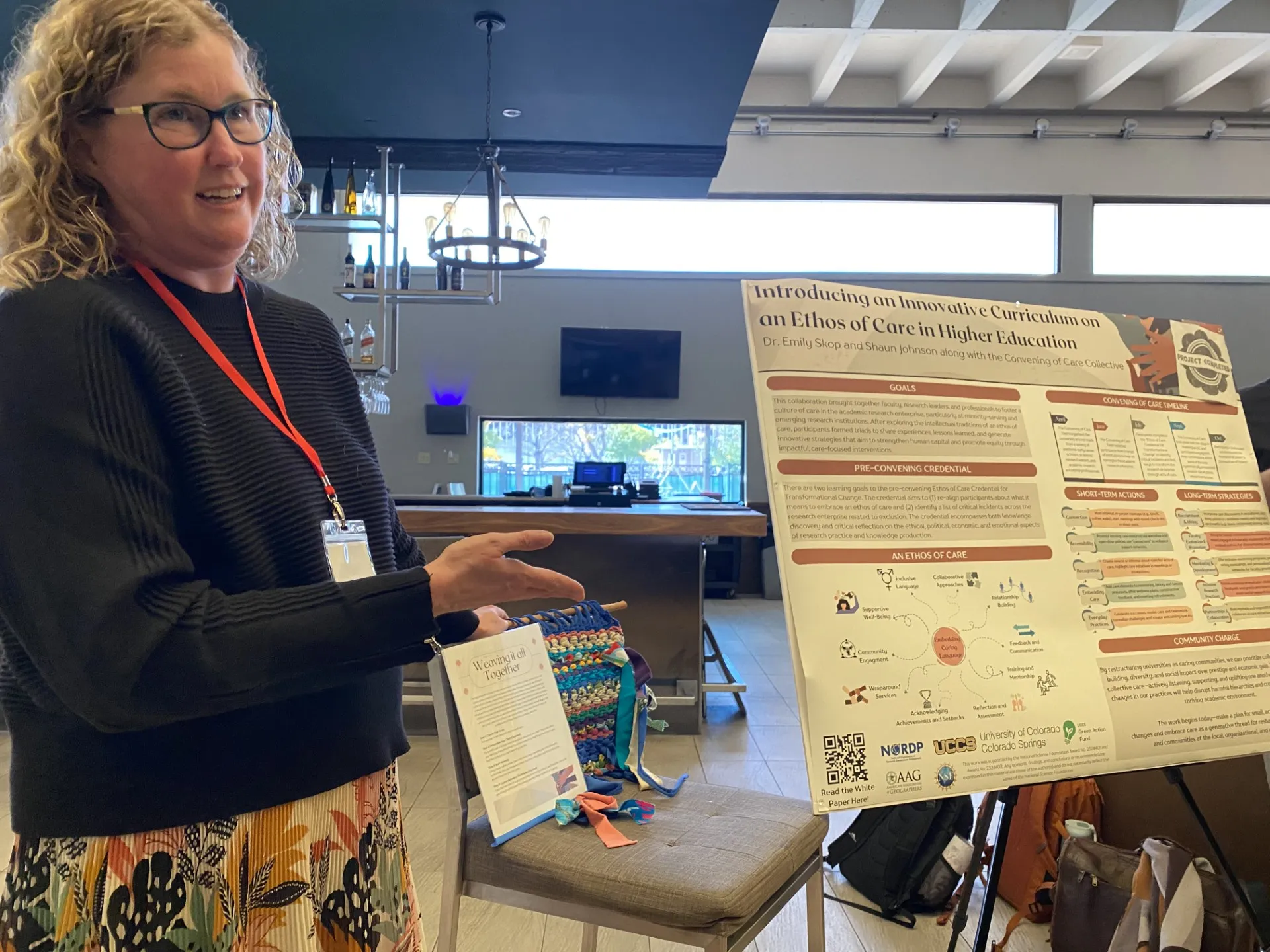 Emily Skop presents a poster about the Ethos of Care at a conference.